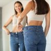 lady wearing oversized jeans comparing size after slimming home