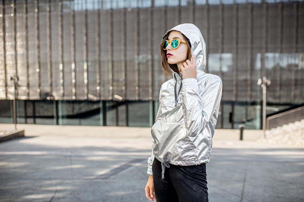 lifestyle portrait stylish woman silver jacket standing outdoors modern urban environment