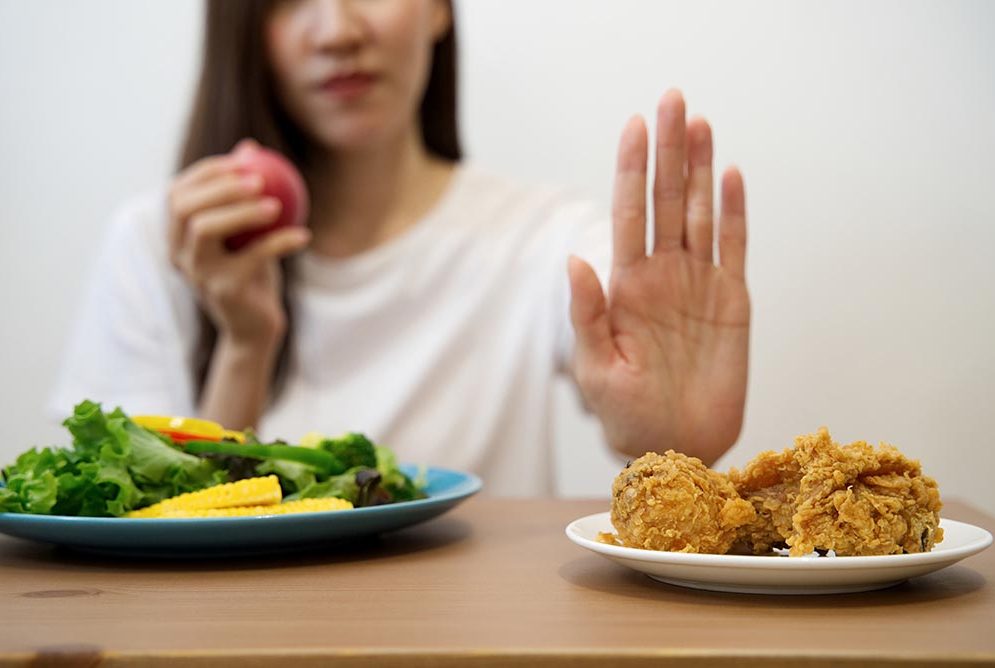 close up female using hand reject junk food by pushing out her favorite fried chicken